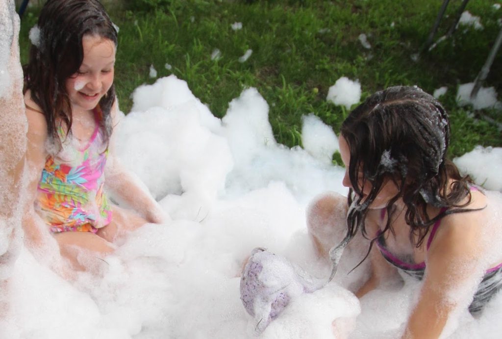 girls playing with diy foam machine
