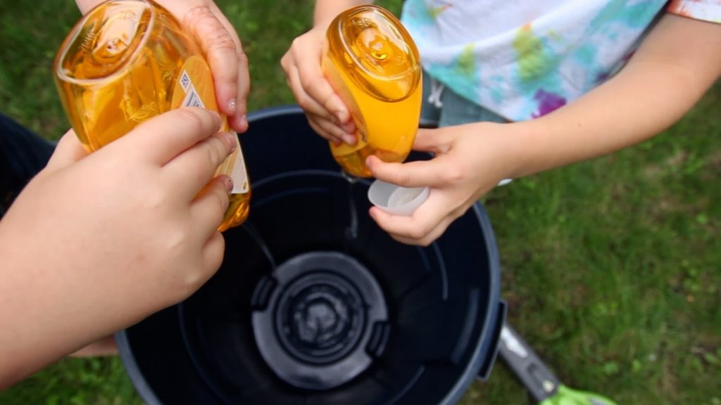 girls filling trash can up with baby shampoo for foam machine