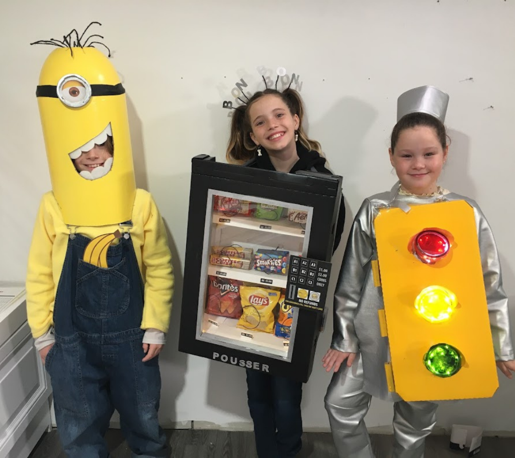 three kids wearing halloween costume made from cardboard boxes
