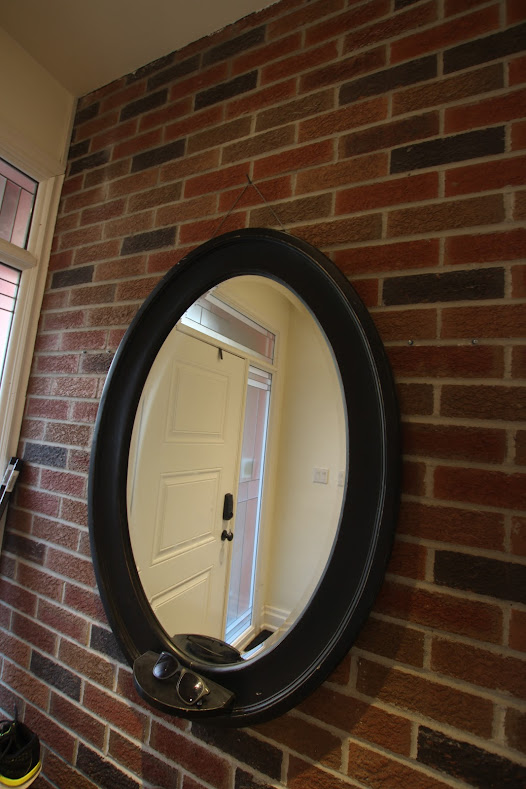 mirror hanging on brick wall