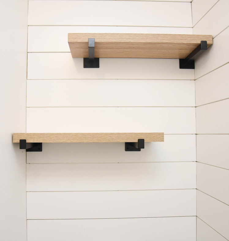 wooden shelves handing on shiplap textured wall