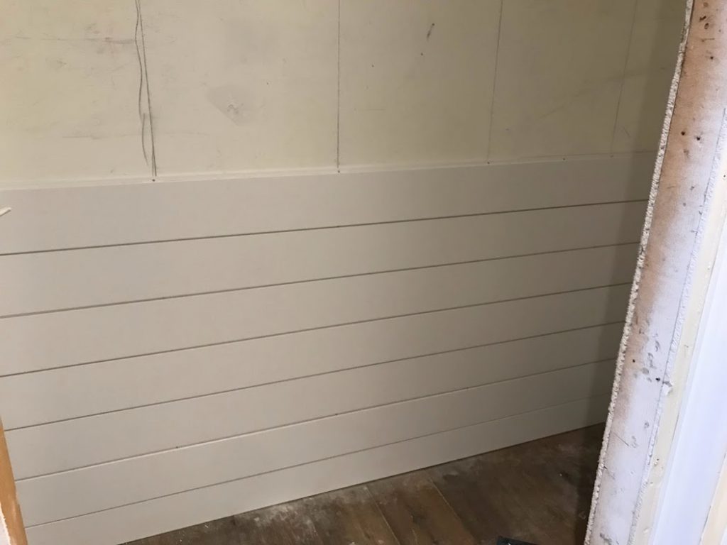 shiplap wall being built in bathroom